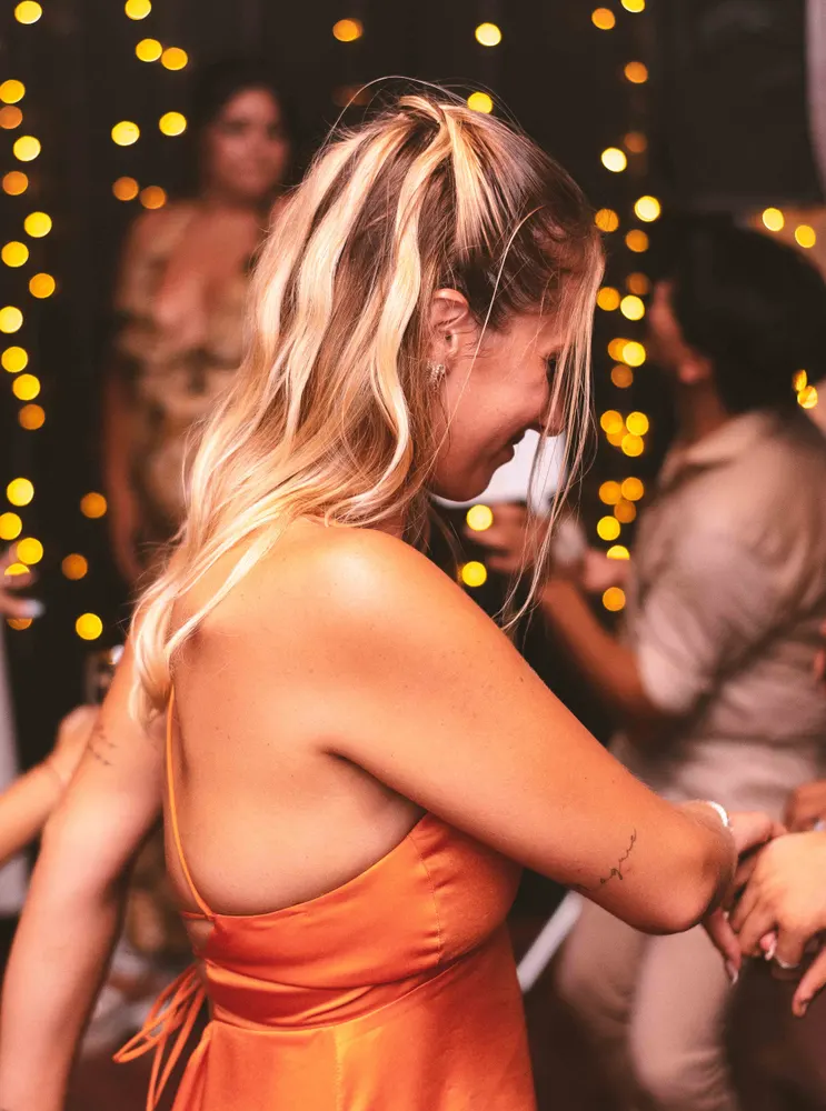 Invitada en una celebración con guirnaldas de luces.