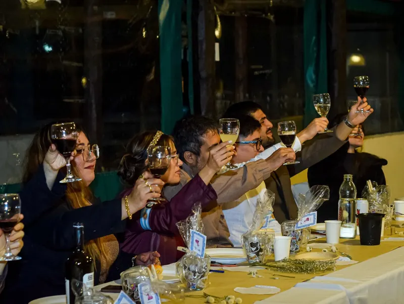 Invitados levantan sus copas durante una celebración de boda.